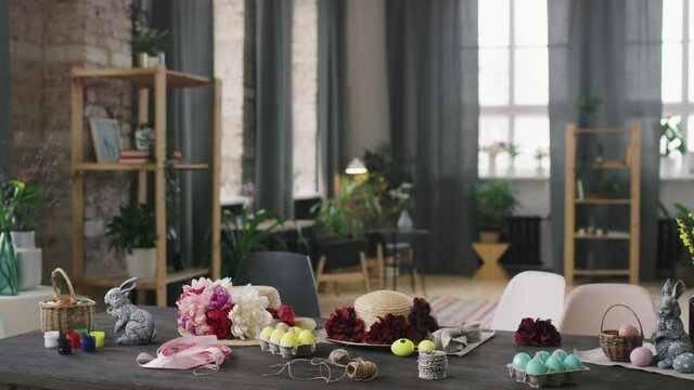 PAN shot of interior of workshop studio with Easter decorations and ornaments lying on wooden table