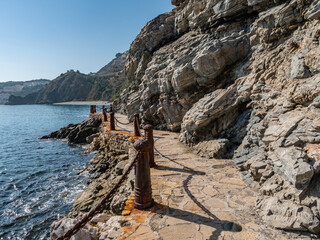 weathered Iron Poles with metal chains at the Cotobro beach near Almu&ntilde;&eacute;car, Granada, Spain