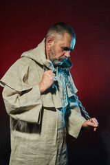 Thoughtful monk with a chain around his neck in color illumination