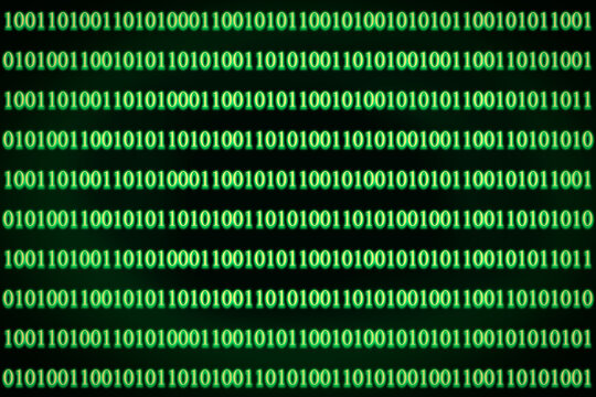 Encrypted binary ASCII computer code on black background. Green binary code computer.