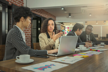 The Latin Business woman present her concept during small group meeting or discussion with her colleague. Modern office or workplace concept.