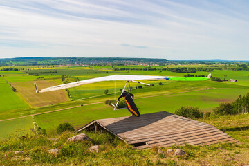 Hang glider start at a ramp on a hill in a beautiful country landscape