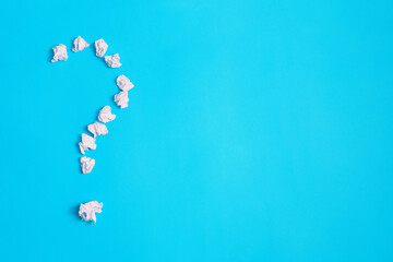 A question mark on a blue background. The question mark is made of crumpled paper.