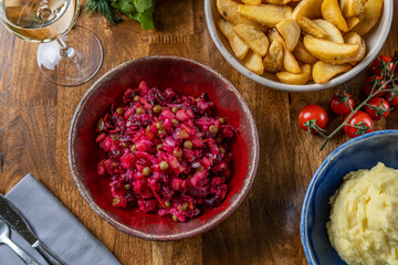 Beet salad in bowl. Vegetarian vegan food. Healthy detox salad with beetroot, potato, carrot, pickles. Enjoying tasty dinner with friends in restaurant. Flat lay. top view