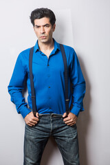 Modello  moro in camicia blu e bretelle, isolato su sfondo bianco