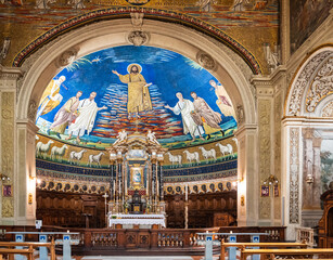 Wide perspective of interior of catholic church in Rome, showing colorful religious painting inside...