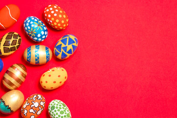 Multicolored Easter eggs on a red background banner. Patterns and designs on colored dyed eggs on a greeting card with congratulations