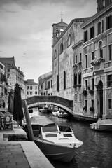 Canal with bridge and moored motorboats in Venice