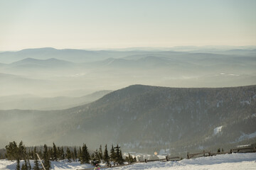 ski resort, landscape of mountains covered with fog in sunny weather