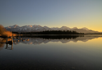 Alpenpanorama in Sonnenuntergang mit der Spiegelung im Hopfensee bei Füssen im Allgäu