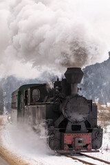 Fototapeta na wymiar Old train with big smoke during winter time in Moldovita, Bucovina. Romaniia.