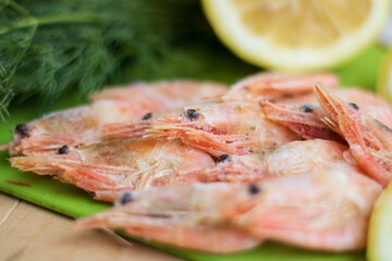 Boiled shrimps or prawns on a white bowl on a white table. Seafood.