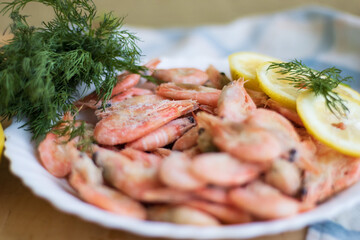 shrimp with lemon and  green salad on a table