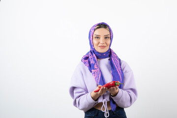 Image of a young woman in handkerchief holding a red pepper
