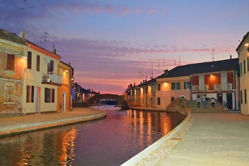 landscape of the characteristic village of Comacchio at sunset time. It is a historic Italian lagoon village also called little Venice, in the province of Ferrara in Emilia Romagna