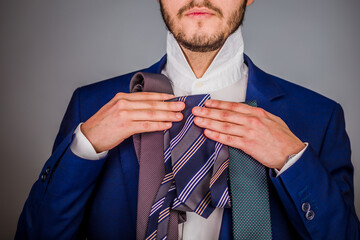 A young hispanic businessman choosing a stylish tie background. Isolated elegant man choose a...