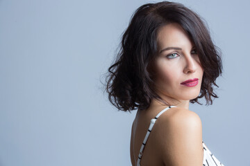 Ritratto di una bellissima ragazza bianca con i capelli neri  vestita  con una tuta bianca a righe...