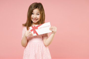 Little kid girl 5-6 years old wears rosy dress have fun hold gift certificate voucher store...