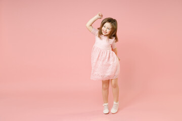 Full length of little kid girl 5-6 years old wears rosy dress have fun dancing fooling around celebrate play isolated on pastel pink background child studio portrait. Mother's Day love family concept.