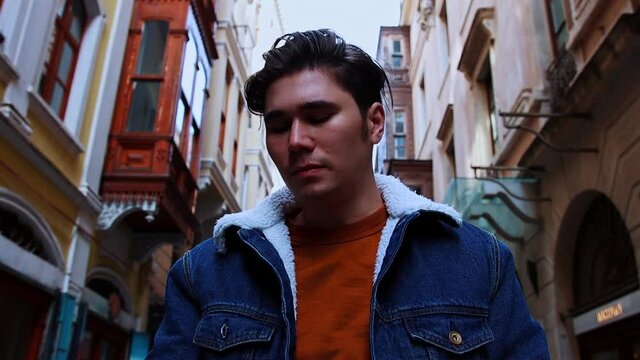 A young pretentious man smoking on the street