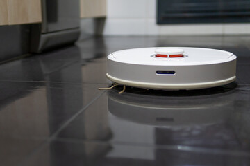 robot vacuum cleaner cleaning the kitchen floor