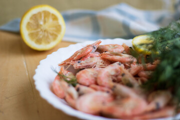 Roasted shrimps with lemon, garlic and herbs. Seafood, shelfish. Shrimps Prawns grilled with spices, garlic and lemon on grey stone background, copy space. Shrimps prawns on plate.