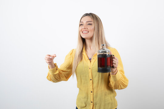 Image of a smiling pretty woman model holding a teapot