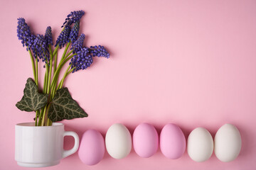 Easter eggs in line and blue spring flowers on pink background