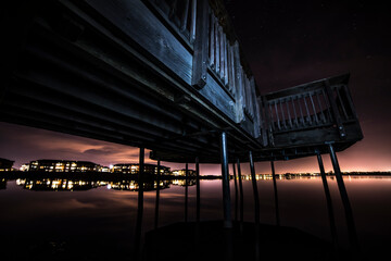 Pier on the water with city reflection on water