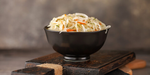 Cabbage salad coleslaw in a bowl on a cutting board
