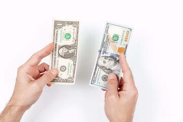 A man hand's holds a U.S. one dollar and hundred dollar. The smallest and largest bill