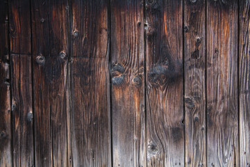 Alte verwitetrte Holzbretterwand mit vielen Astlöchern und starker Maserung