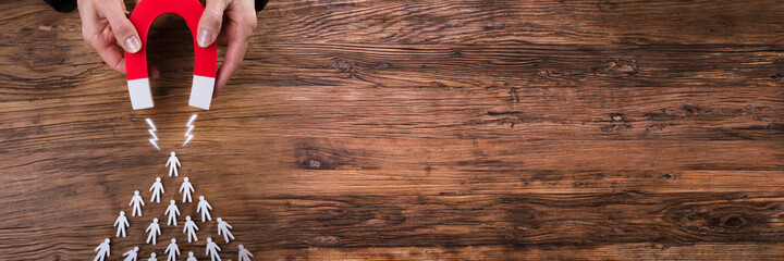 Businessperson Attracting Human Figures With Horseshoe Magnet