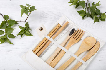 Set of Eco friendly bamboo cutlery in a case on wooden white background. Sustainable lifestyle....