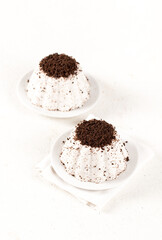Vanilla jelly with chocolate chip cookie crumbs on a plate on a white background