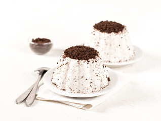 Creamy jelly with chocolate chip cookie crumbs on a plate on a white background