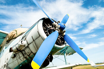 Old plane propeller. Vintage fighter plane closeup by blue sky