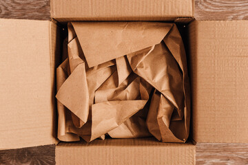 Cardboard boxes with crumpled paper inside for packaging goods from online stores, eco friendly packaging made of recyclable raw materials