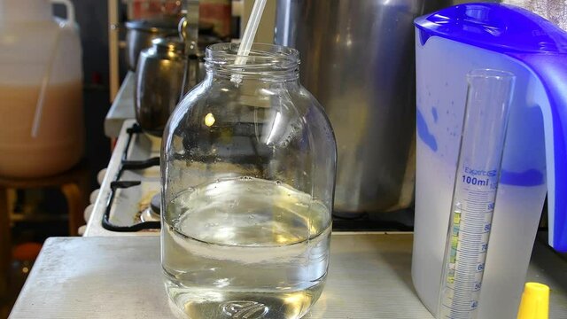 The process of distilling moonshine from mash. Moonshiner prepares strong alcohol at home. 