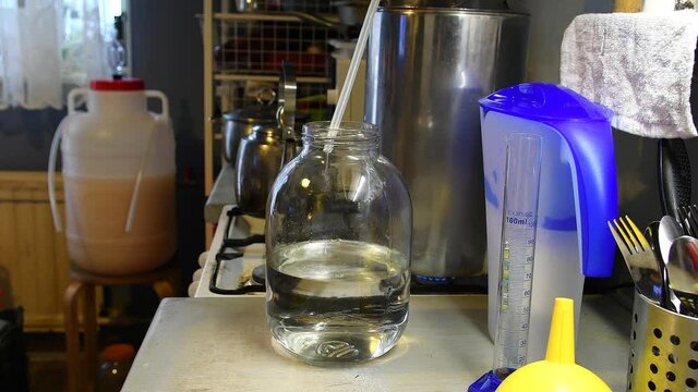 Distilling moonshine from a brew on home equipment. Moonshiner prepares strong alcohol workflow.