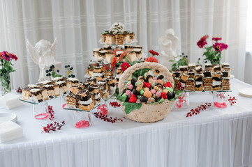 Sweet cakes at a wedding banquet. Catering, sweet festive buffet. Candy bar