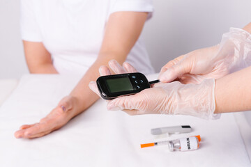 A closeup of doctor hands prepares to performing an insulin test on a patient in the hospital. White background and medical care concept