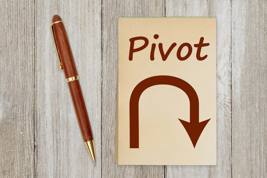 Pivot Message With Arrow On Old Paper Notepad With A Pen