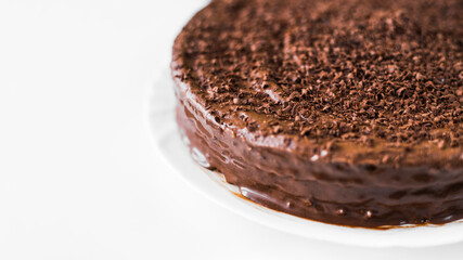 Homemade chocolate cake in a plate on a white background. Empty space for text. Flat lay top-down