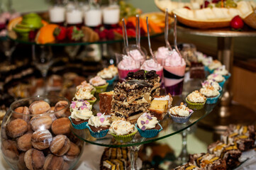 Sweet cakes at a wedding banquet. Catering, sweet festive buffet. Candy bar