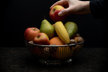 fruit bowl and a hand taking an apple