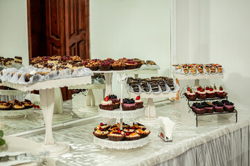 Sweet cakes at a wedding banquet. Catering, sweet festive buffet. Candy bar