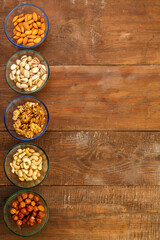 Assorted nuts in a glass bowl on a wooden table. copy space.
