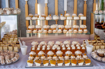 Sweet cakes at a wedding banquet. Catering, sweet festive buffet. Candy bar