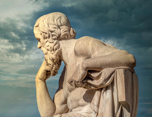 Socrates the ancient Greek philosopher in deep thoughts under impressive sky, Athens Greece.